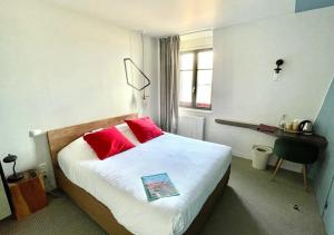 a hotel room with a bed with red pillows at Hôtel Restaurant Ar Iniz in Saint Malo