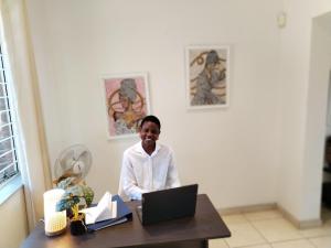 a woman sitting at a desk with a laptop computer at Paulshof Guesthouse - Kingsway B&B in Sandton +64 photos