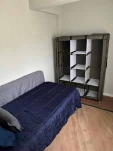 a bedroom with a bed and a book shelf at Frente ao mar, conforto e paz apto 12 in Praia Grande