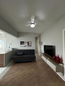 a living room with a couch and a flat screen tv at Frente ao mar, conforto e paz apto 12 in Praia Grande