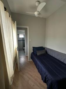 a bedroom with a blue bed in a room at Frente ao mar, conforto e paz apto 12 in Praia Grande +30 photos