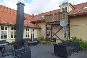 a patio with chairs and tables and a building at Hotel garni Goldene Henne in Arnstadt