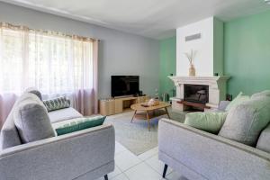 a living room with two couches and a fireplace at Le Vert Bocage - Avec Jardin in Rouvroy-sur-Serre