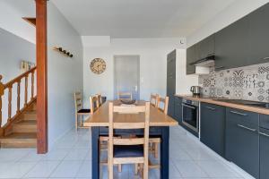 a kitchen with a wooden table and a dining room at Le Vert Bocage - Avec Jardin in Rouvroy-sur-Serre
