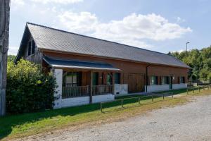 a brown and white building with a fence around it at Le Vert Bocage - Avec Jardin in Rouvroy-sur-Serre