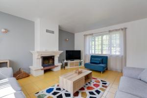 a living room with a couch and a fireplace at L'Orée du Bois - Avec Jardin in Rouvroy-sur-Serre