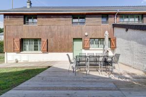 a patio with a table and chairs in front of a building at L'Orée du Bois - Avec Jardin in Rouvroy-sur-Serre