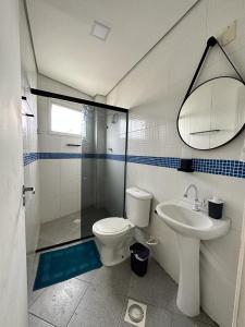 a bathroom with a toilet and a sink and a shower at Frente ao mar, conforto e paz apto 12 in Praia Grande