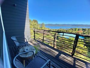 a balcony with two chairs and a view of the water at Huillín Lodge in Huillinco