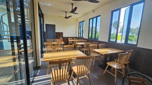 a restaurant with wooden tables and chairs and windows at Oceara Dharavandhoo in Dharavandhoo