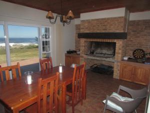 una sala da pranzo con tavolo e camino di 30 Branderdraai a Hermanus