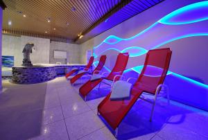 a waiting room with red chairs and a statue at Hotel Simi in Zermatt