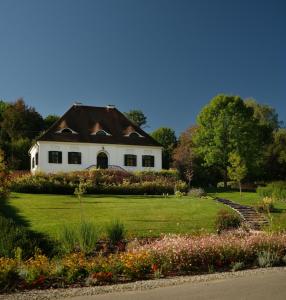 een wit huis met een bruin dak in een tuin bij Bethlen Estates Transylvania in Daneş
