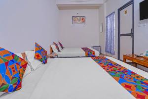 sala de estar con 2 camas y almohadas coloridas en Via Lishikaas Inn, en Tākalghāt 20 fotos más
