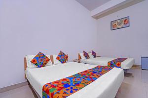 Una habitación con dos camas con sábanas de colores. en Via Lishikaas Inn, en Tākalghāt