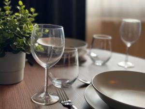 a table with wine glasses and plates and a plant at Gemütliche Innenstadt Apartments in Stuttgart Stadtmitte in Stuttgart