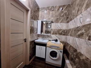 ein Badezimmer mit Waschbecken und Waschmaschine in der Unterkunft Однокімнатна вартира на Садовому з кондиционером in Shcherbani