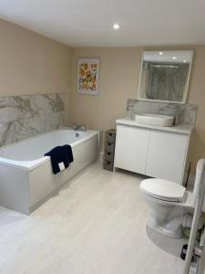 a bathroom with a tub and a toilet and a sink at Three bedroom cabin with rural views and hot tub in Algarkirk +3 photos