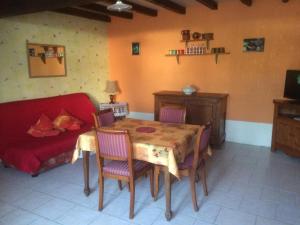a living room with a table and a red couch at Chez Manon in Grimault +4 photos