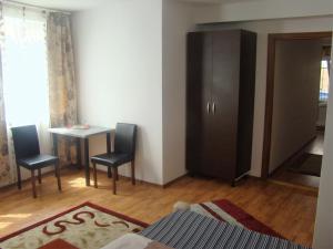 クルジュ・ナポカにあるGuest House Andreiのベッドルーム(キャビネット、テーブル、椅子付)