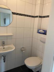 een badkamer met toilet en wastafel bij Meeresbrise 14 in Wangerland +7 foto's