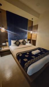 una camera da letto con un letto grande con testiera blu di hotel beachfront a Calangute Altre 18 foto