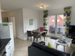 een woonkamer met een bank en een tafel met stoelen bij Meeresbrise 14 in Wangerland