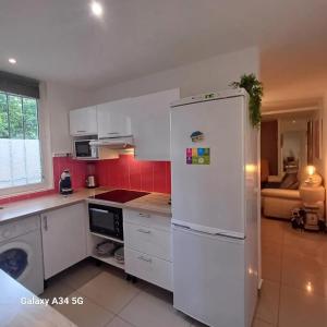 パライユ・ヴィエイユ・ポストにあるAppartement moderne à Paray-Vieille-Poste, 50m², avec terrasseのキッチン(白い冷蔵庫付)