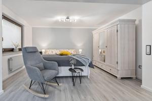 a bedroom with a bed and a chair and a cabinet at Ferienwohnung an der Volme in Meinerzhagen
