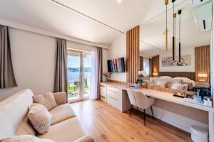 a living room with a couch and a table with chairs at Bed & Breakfast Villa Vrgorac in Orebić