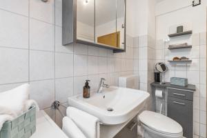 a white bathroom with a sink and a toilet at Ferienwohnung an der Volme in Meinerzhagen +20 photos