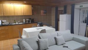 een woonkamer met een bank en een keuken bij Casa do Avô Almeida in Fajazinha
