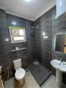 un baño con inodoro y lavabo en ArQa pyramids Hotel, en El Cairo