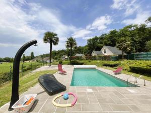 a swimming pool with two chairs next to a swimming pool at Gite l'oree du bois in Livron