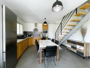 a kitchen with a table and chairs and a staircase at Gite l'oree du bois in Livron