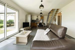 a living room with a leather couch and a table at Gite l'oree du bois in Livron