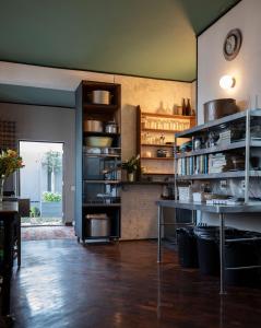 a kitchen with a table and shelves in a room at Axminster House in Muizenberg