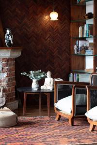 a living room with a table with a vase of flowers at Axminster House in Muizenberg