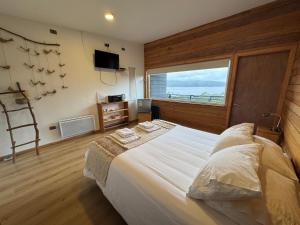 Un dormitorio con una cama grande y una ventana grande en Huillín Lodge, en Huillinco