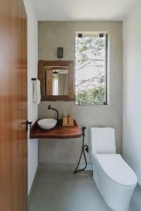 een badkamer met een toilet, een wastafel en een spiegel bij Refúgio Wyrá in Itacaré +52 foto's