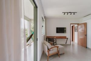 een woonkamer met een stoel en een tafel bij Refúgio Wyrá in Itacaré