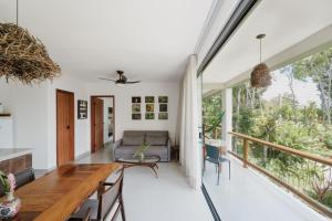 een woonkamer met een tafel en een bank bij Refúgio Wyrá in Itacaré