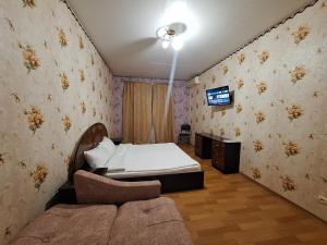 ein Schlafzimmer mit einem Bett und einem Fernseher an der Wand in der Unterkunft Однокімнатна квартира на Садовому на першому поверсі in Shcherbani