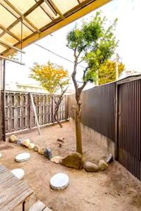 a courtyard with a tree and a fence at まほら in Fukuoka