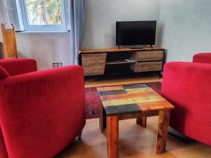a living room with two red chairs and a television at Suites on 74 in Worcester
