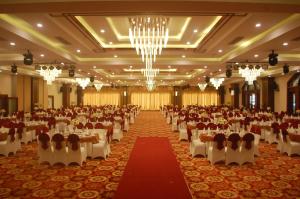 a large banquet hall with tables and chairs and chandeliers at Hai Yen Luxury Hotel in Cẩm Phả