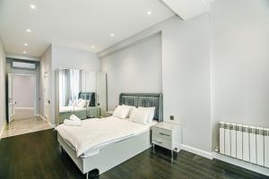 a white bedroom with a bed and a mirror at Lux Apartment View Baku Formula 1 Street in Baku