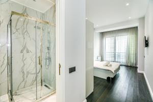 a bathroom with a walk in shower next to a bed at Lux Apartment View Baku Formula 1 Street in Baku +69 photos