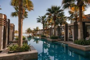 a pool at the resort with palm trees at Jumeirah Muscat Bay Oman in Muscat