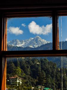 a view of a mountain from a window at Artllers at Vicctoria House, All Mountain View rooms with Free Parking in McLeod Ganj